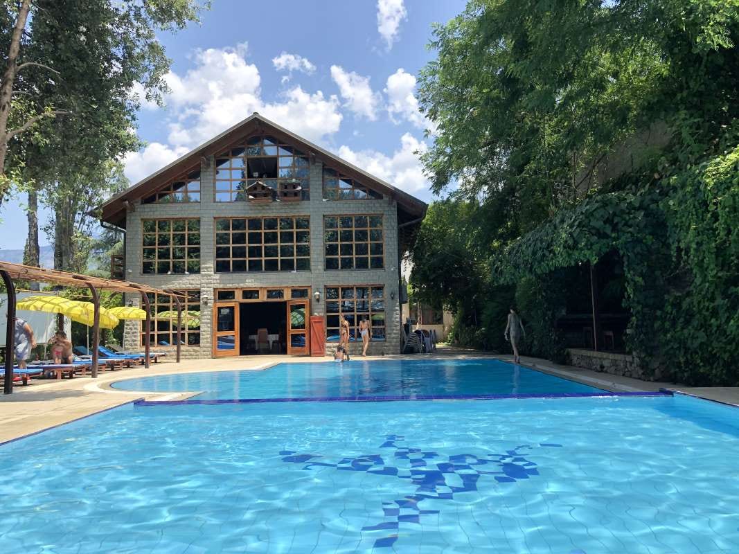 Albanian traditional stone house beside a swimming pool