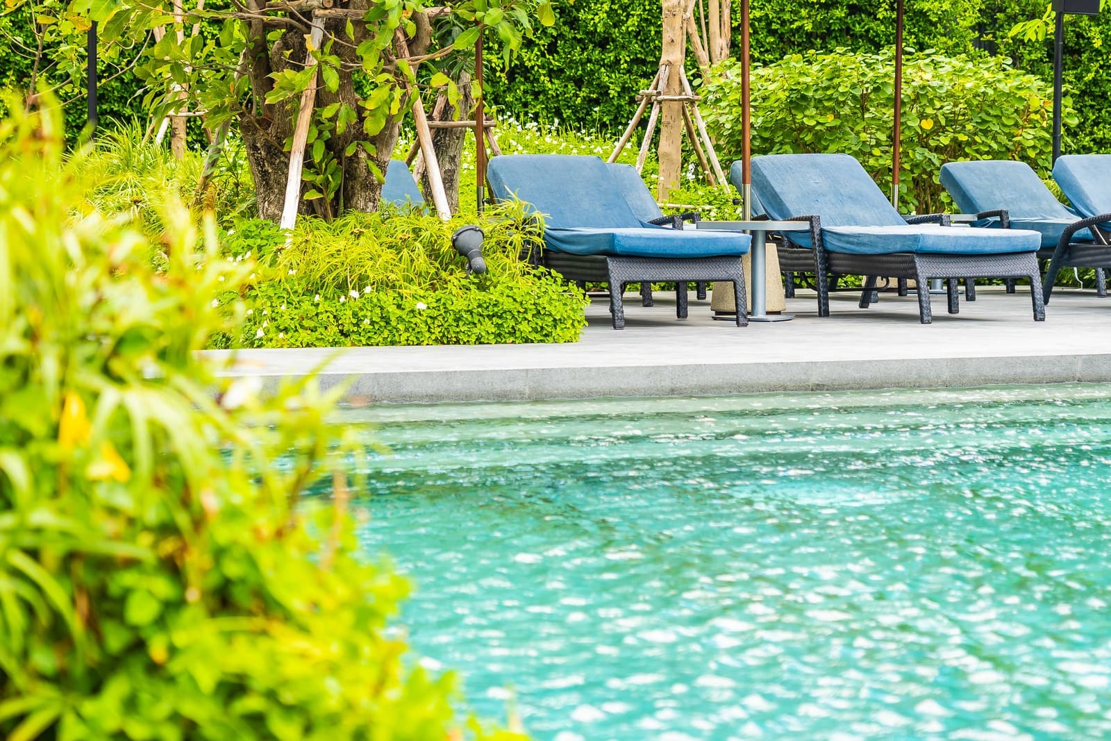 Outdoor hotel resort swimming pool with lounge chairs and vacation setting