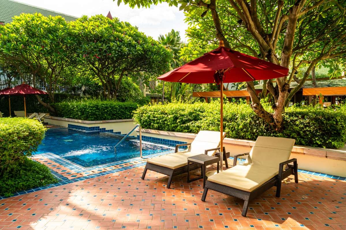 Poolside lounge chairs beside a resort swimming pool for a vacation setting