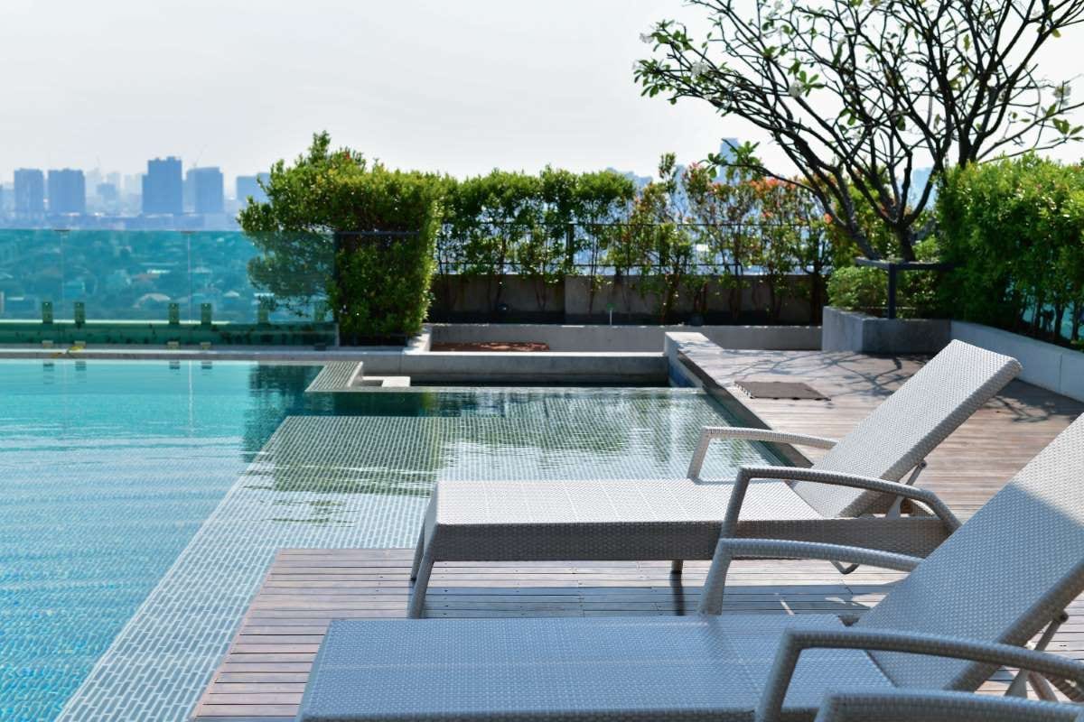 Chairs by a swimming pool against a clear sky