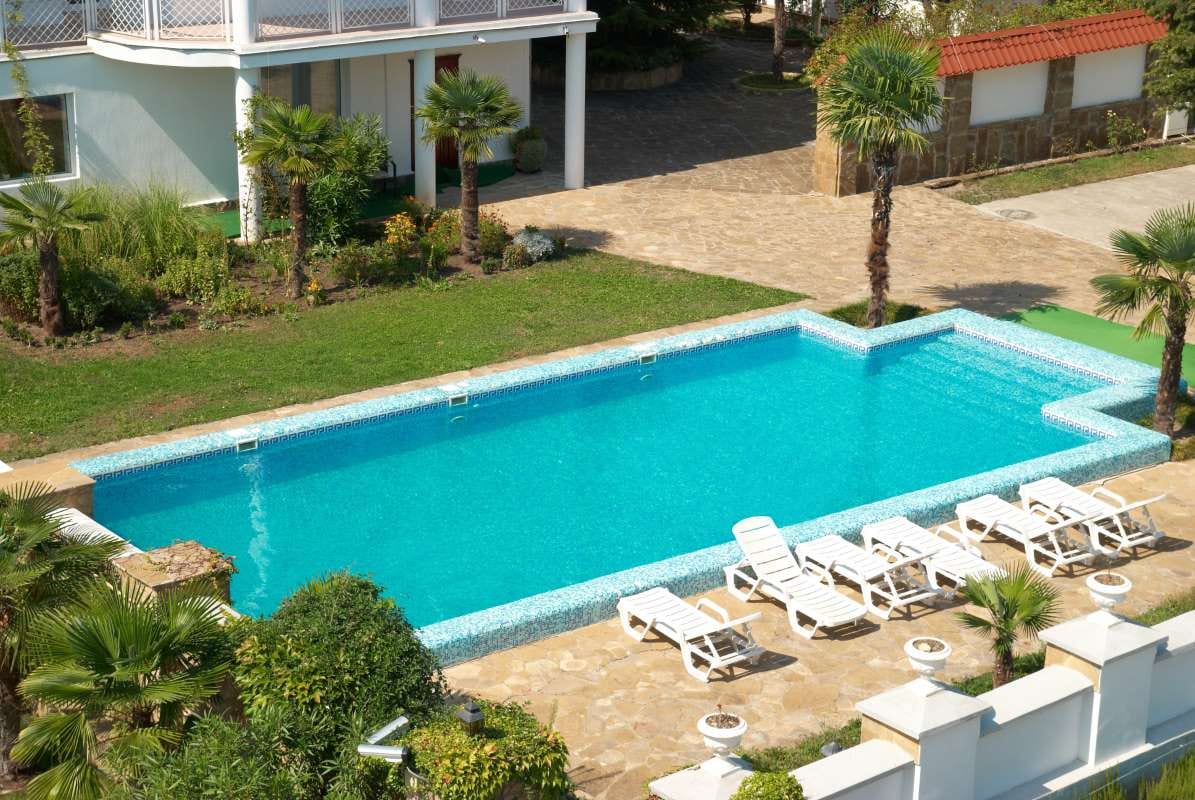 House with blue pool in a yard during monsoon weather