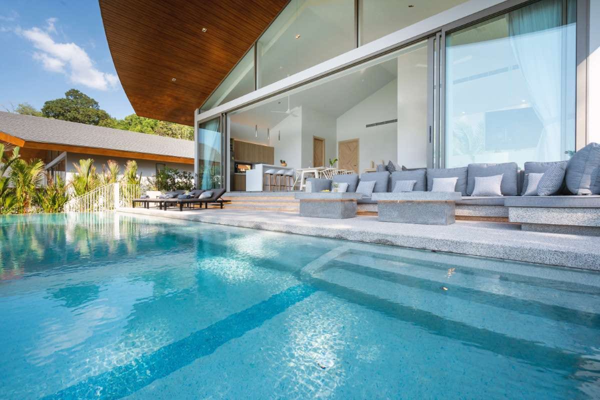Modern villa with infinity pool and sun beds, interior-exterior design view