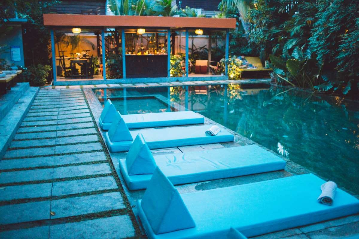 Lounge chairs by a swimming pool beside a building