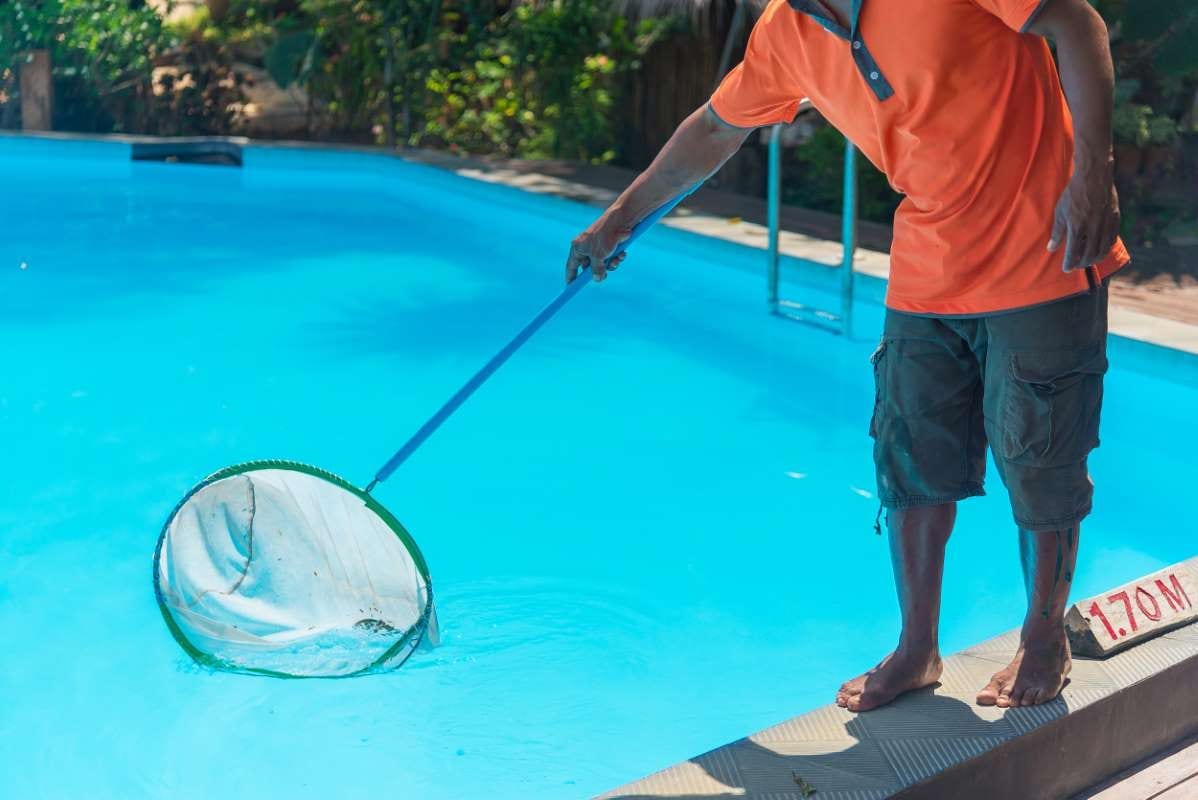 Technician standing beside a swimming pool, ready for service work