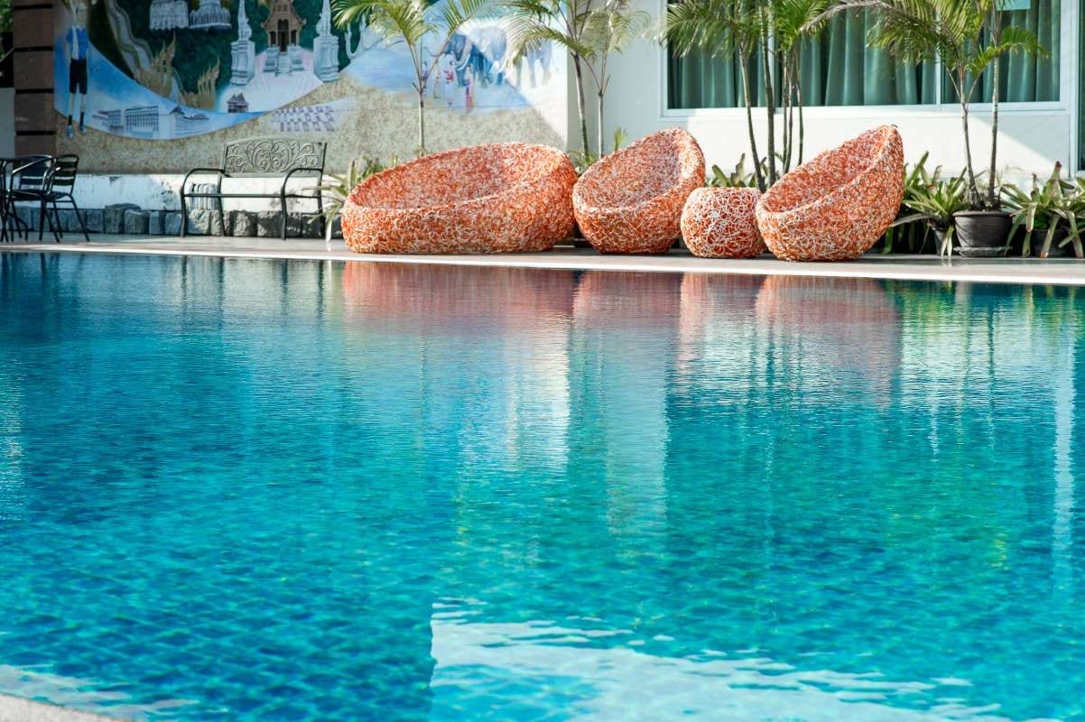 Chairs reflected beside a swimming pool, evoking pool service invoicing setup