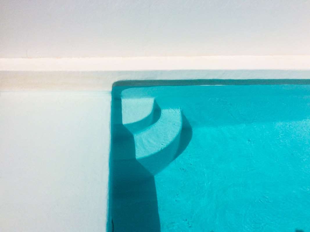 Swimming pool casting a shadow against the sea