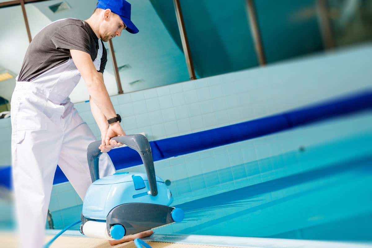 Technicians working beside a swimming pool, viewed from the side