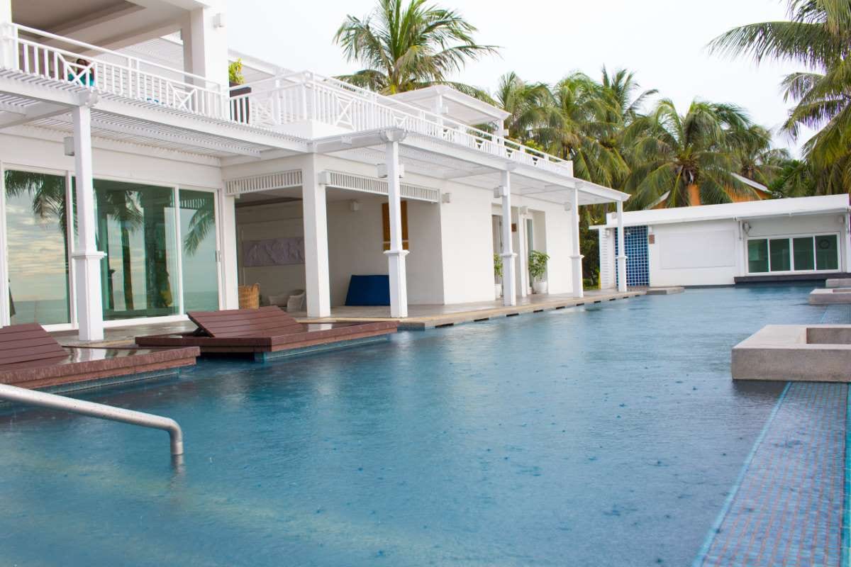 Swimming pool by palm trees against a clear sky