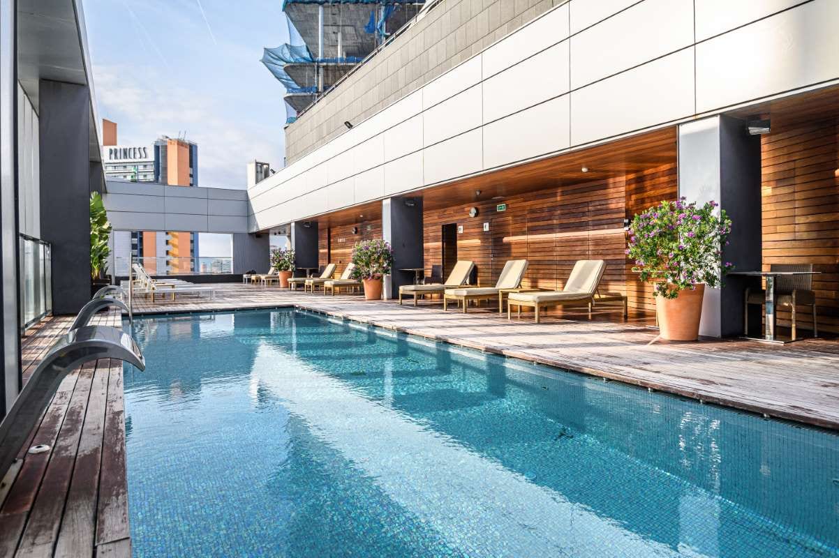 Rooftop swimming pool with city skyline at a premium Barcelona hotel