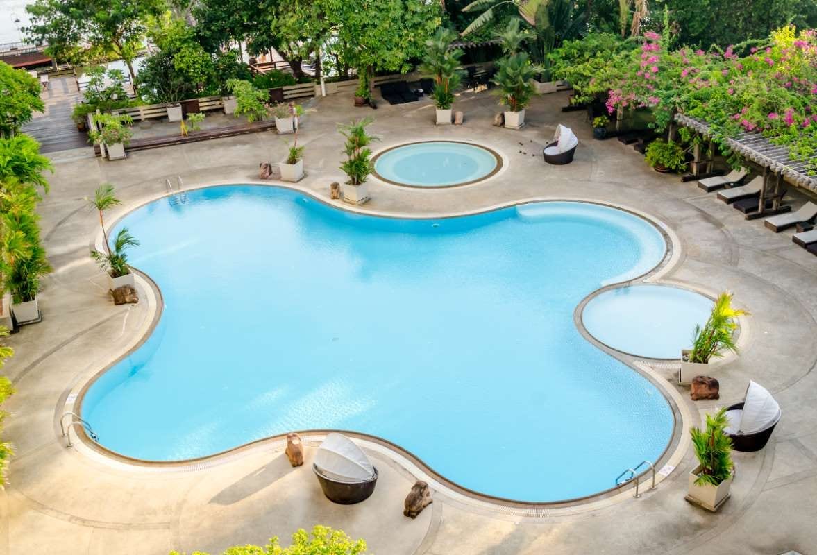 Hotel swimming pool view with turquoise water and deck chairs